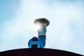 Portable ventilation pipe with electric motor against the background of the sky and the sun. Close-up