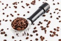 Portafilter filled and surrounded with whole coffee beans isolated on white background. Royalty Free Stock Photo