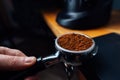 Portafilter full of ground coffee in a hand Royalty Free Stock Photo
