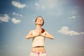 Portait of beautiful young woman doing joga on the wonderful sky