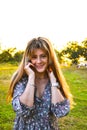 Portait of beautiful young woman at sunset. Young girl enjoys the sunshine in a summer park. Happy woman enjoying nature Royalty Free Stock Photo