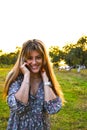Portait of beautiful young woman at sunset. Young girl enjoys the sunshine in a summer park. Happy woman enjoying nature on sunny Royalty Free Stock Photo