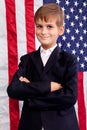 Portait of Caucasian boy with American flag in background Royalty Free Stock Photo