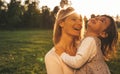 Portait of cheerful happy girl kid playing with her mother outdoor on sunset. Portrait of woman and her cute child laughing in the Royalty Free Stock Photo