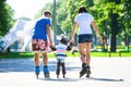 Cute baby boy and his mom learning inline skating Royalty Free Stock Photo