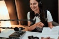 Portait of happy female radio host smiling and giving a script paper to her male colleague while moderating a live show Royalty Free Stock Photo