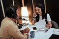 Portait of happy female radio host smiling, talking to male guest, presenter while moderating a live show in studio Royalty Free Stock Photo