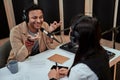 Portait of happy male radio host smiling, talking to female guest while moderating a live show in studio Royalty Free Stock Photo