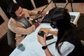 Portait of male radio host working on a sound mixing desk, adjusting levels, turning up volume while moderating a live Royalty Free Stock Photo