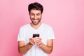 Portait of positive cheerful middle eastern man use his cellphone follow feednews blogs true blogger wear style white