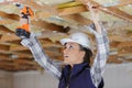 Portait woman drilling roof