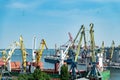 Portal port crane in the port. Logistics business. Huge cranes and containers, sunny summer day. Royalty Free Stock Photo