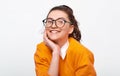 Portarit of cheerful student girl smiling broadly, wears orange sweater and round transparent eyewear. Pretty positive young woman