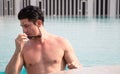 Portarit handsome, muscular caucasian white man wearing sunglasses in a swimming pool summer vacation