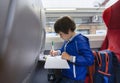 Portarit Kid traveling by the train, Child drawing cartoon on white paper sitting by the window. Little boy in a high speed