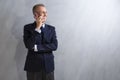 Portarit of Smiling Caucasian Man in Blue Suit Speaking on Cellphone. Posing Against Grunge Wall