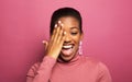 Portarit of young beautiful african-american young woman smiling broadly and close eye over pink background