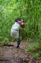 A porter carrying a heavy load and walking in the rain forest at
