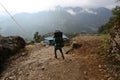 Porter carrying heavy loads on the way to Everest base camp in Easter Nepal