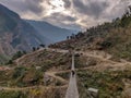 Porter crossing suspension bridge in remote village of Nepal.