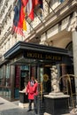 Porter in red uniform next to the sacher hotel door waiting guests