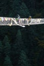 Porters carry heavy luggage on suspension bridge in Khumbu valley on a way to Everest Base camp Royalty Free Stock Photo