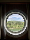 Porthole view to the sea and trees