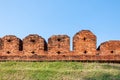 A portion of the ancient fortified city wall built of brick with cross bow cutouts and crenelations