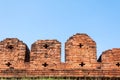 A portion of the ancient fortified city wall built of brick with cross bow cutouts and crenelations