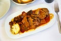 Portion of braised beef with mushrooms and potato served on table