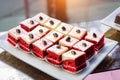 Portion cakes with cream. Dessert red velvet, close-up. Sweets at festive banquet