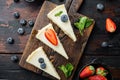 Portion of cheesecake with berries, on old dark wooden table background, top view flat lay