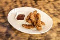 Portion of chicken fingers battered in wheat flour with egg and breadcrumbs