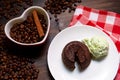 A portion of chocolate fondant with a scoop of pistachio ice cream on a plate.