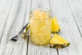 Portion of Chopped Pineapple preserved on wooden background, s