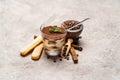 Portion of Classic tiramisu dessert in a glass cup, scoop full of coffee and cinnamon sticks on concrete background