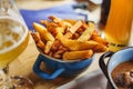 Portion of crispy golden spiced potato wedges in a blue bowl restaurant serving french fries. Potato wedges as food for friday