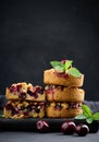 Portion crumble pie with cherries on a wooden board decorated with green mint leaves