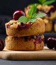 Portion crumble pie with cherries on a wooden board decorated with green mint leaves