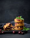 Portion crumble pie with cherries on a wooden board decorated with green mint leaves, black background