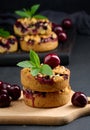 Portion crumble pie with cherries on a wooden board decorated with green mint leaves