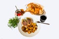 Portion of deer meat, potato and sauce on plate, meat in baking paper, pot, herbs and wine Royalty Free Stock Photo