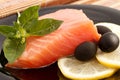 The portion of delicious salmon with basil, lemon and olives