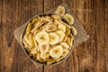 Portion of Dried Banana Chips on wooden background, selective focus Royalty Free Stock Photo