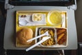 Portion of food for one passenger in cardboard box at airplane board.