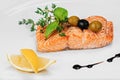 Healthy balanced seafood lunch - grilled red fish fillet salmon with rosemary herb, olives and lemon slices on light plate Royalty Free Stock Photo