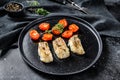 A portion of Grilled, baked pollock or coalfish fillets. Black background. Top view