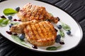 Portion of grilled pork steak with ribs with fresh blueberry sauce and baby spinach closeup on a plate. horizontal Royalty Free Stock Photo