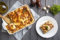 Portion of ground beef lasagna topped with melted cheese and garnished with fresh parsley served on a plate in close view for a