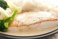 Portion of halibut in a cream sauce served with boiled rice, cauliflower, and broccoli Royalty Free Stock Photo